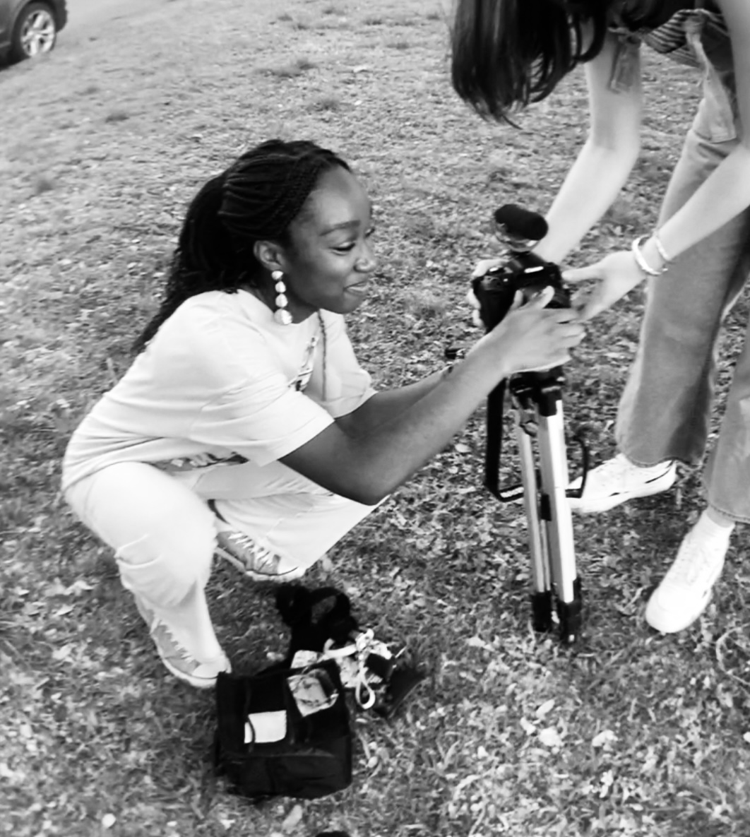 Chinomso Nicole working with a camera on an outdoor film set