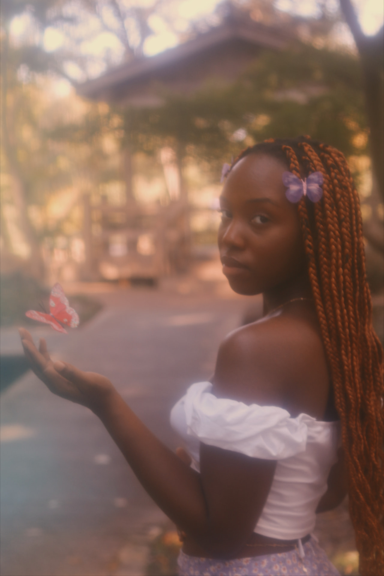 A woman releasing a pink butterfly from her open hand in golden light