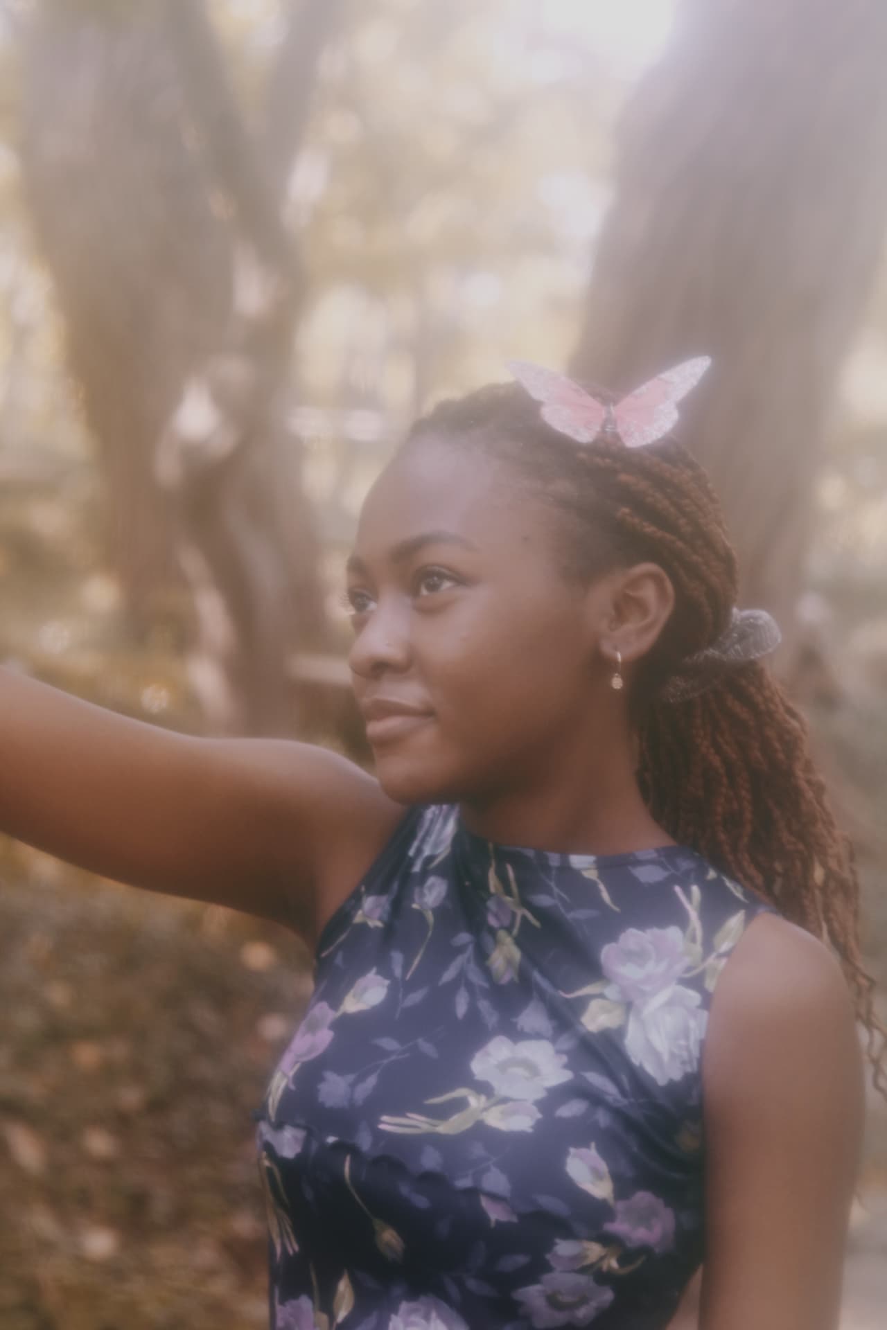 Portrait of a woman in a floral dress with a pink butterfly in her hair